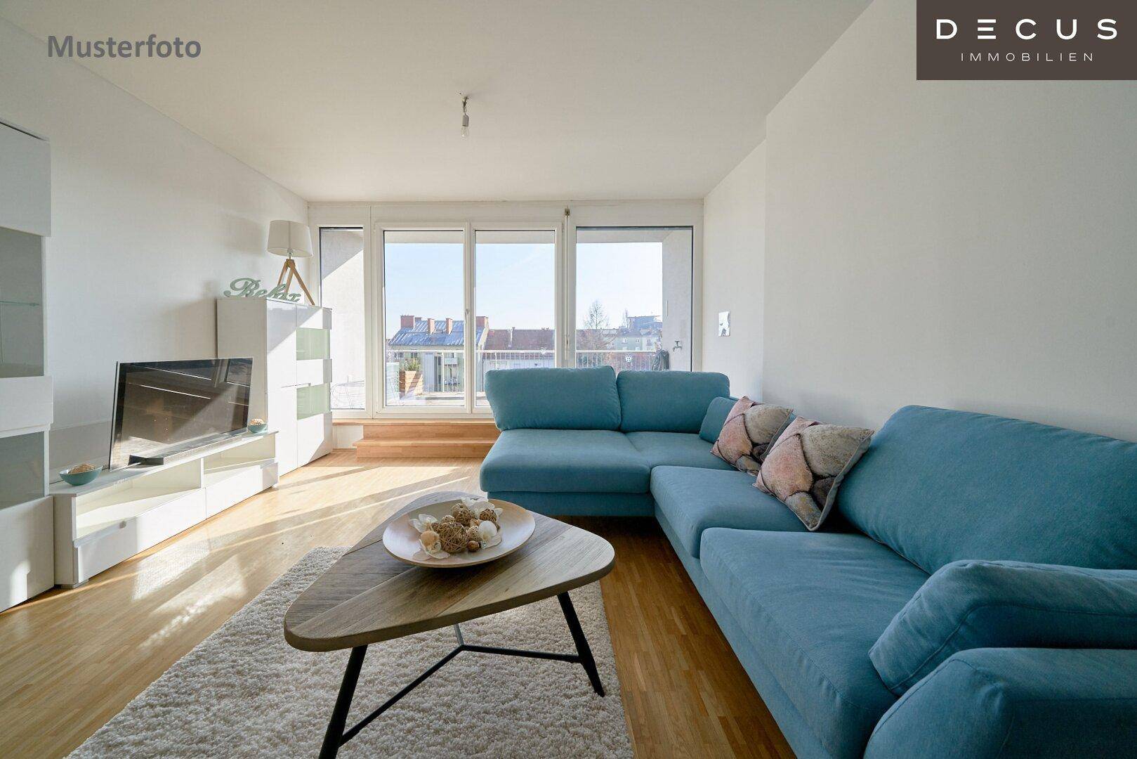 Helles Wohnzimmer mit Holzboden, modernem Sofa und großen Fenstern mit Stadtblick.