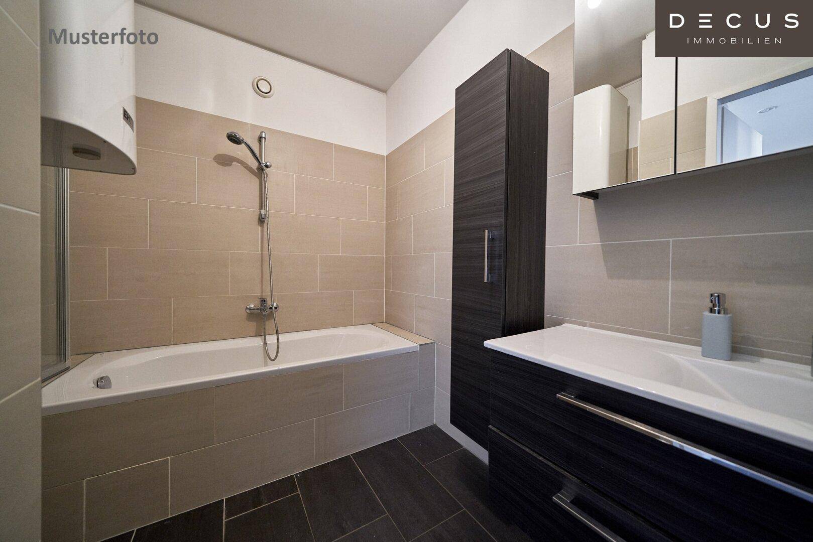 Modernes Badezimmer mit beigefarbenen Wandfliesen, Badewanne und dunklem Waschtischunterschrank.