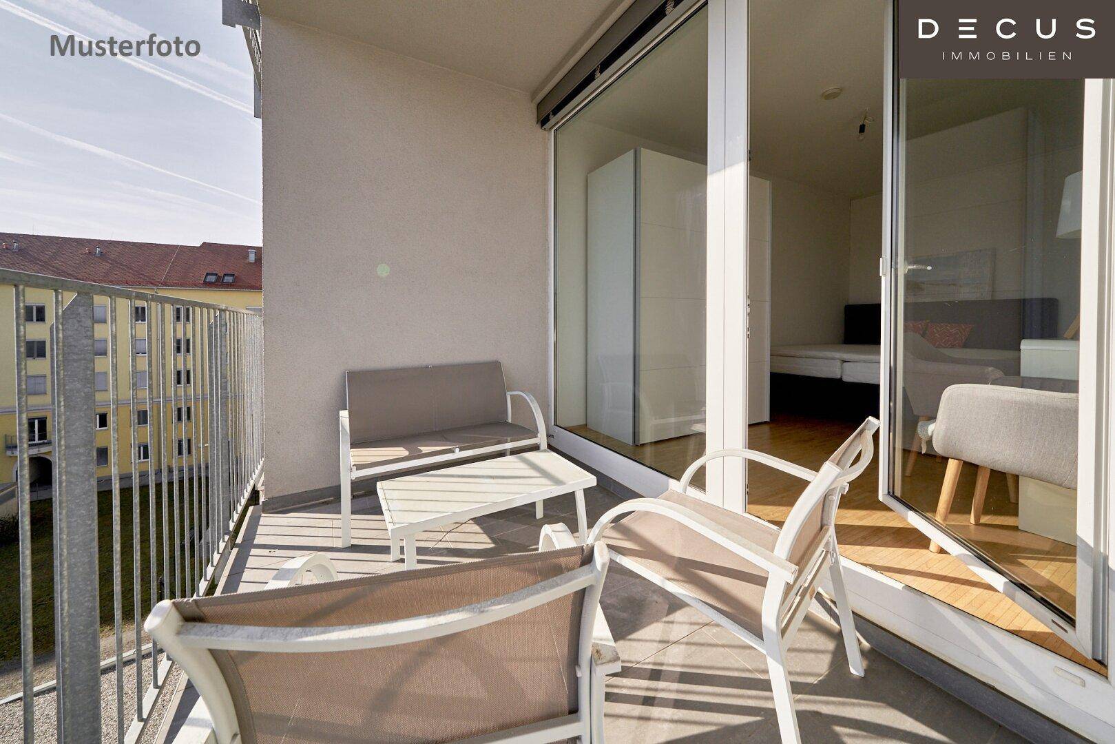 Möblierter Balkon mit Sitzgelegenheiten und Blick auf die umliegenden Gebäude und den Innenhof.
