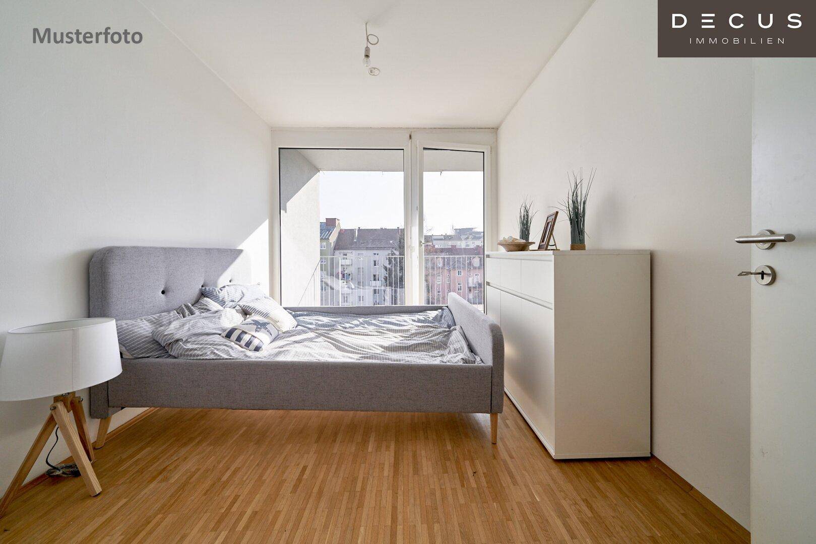 Gemütliches Schlafzimmer mit Holzboden, Doppelbett und Zugang zu einem kleinen Balkon.