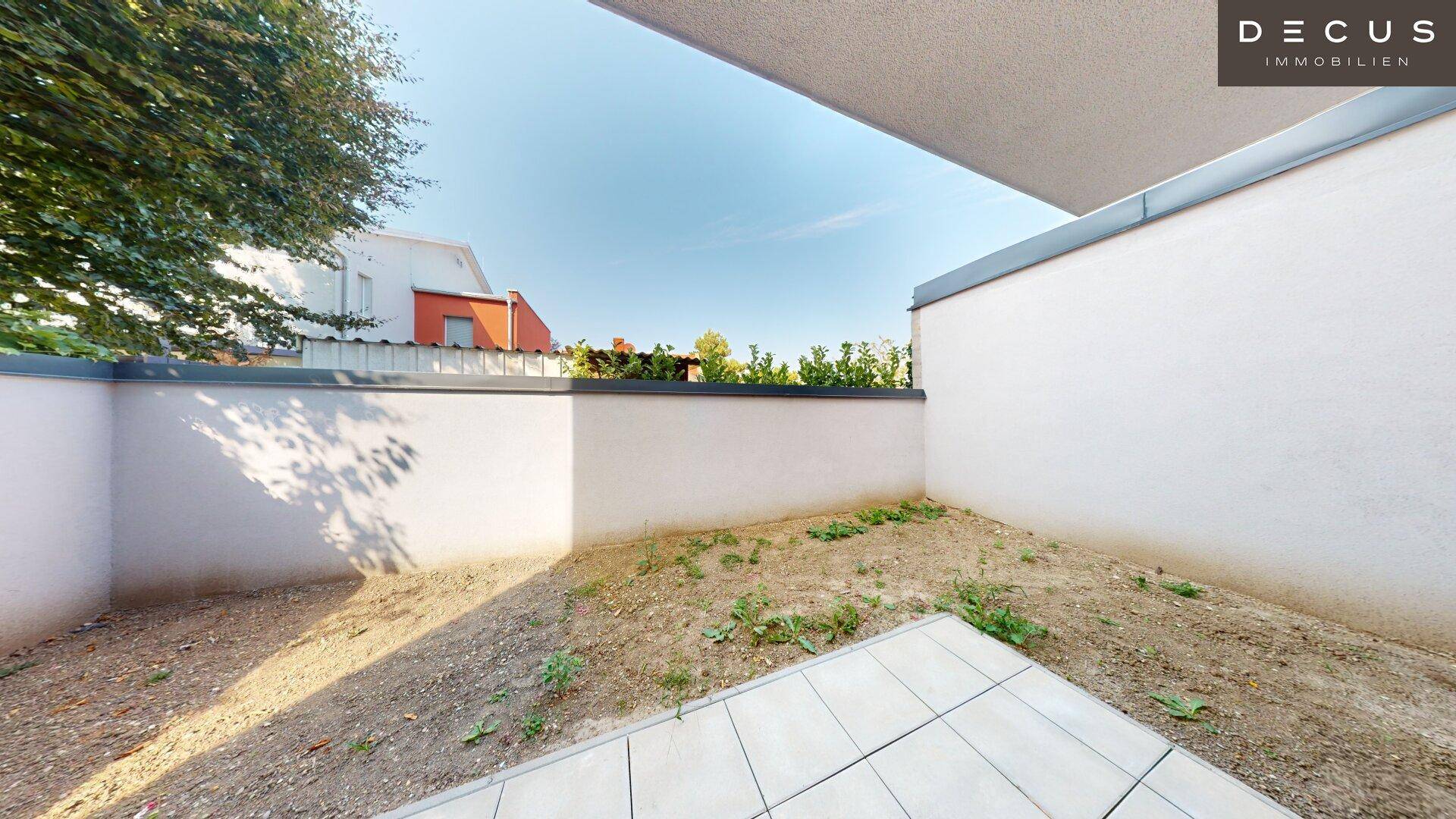 Kleiner, ummauerter Gartenbereich mit Fliesenfläche, ideal für eine zukünftige Gestaltung.