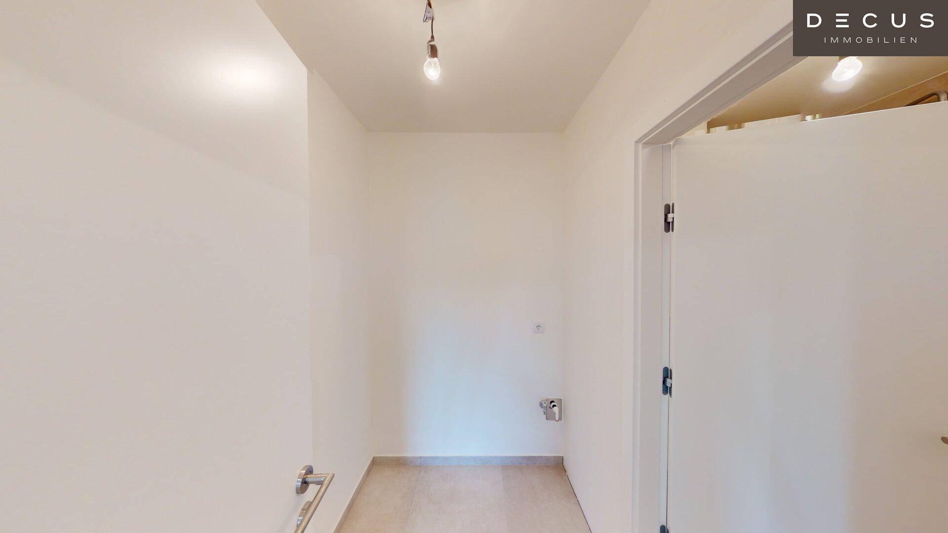 Kleiner Raum mit Fliesenboden und sichtbaren Anschlüssen, ideal als Hauswirtschaftsraum.