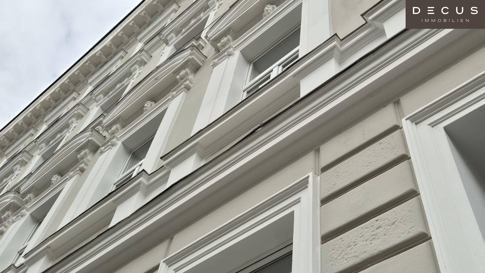 Detailansicht der eleganten Stuckfassade mit klassischen Verzierungen und gut erhaltenen Fenstern.