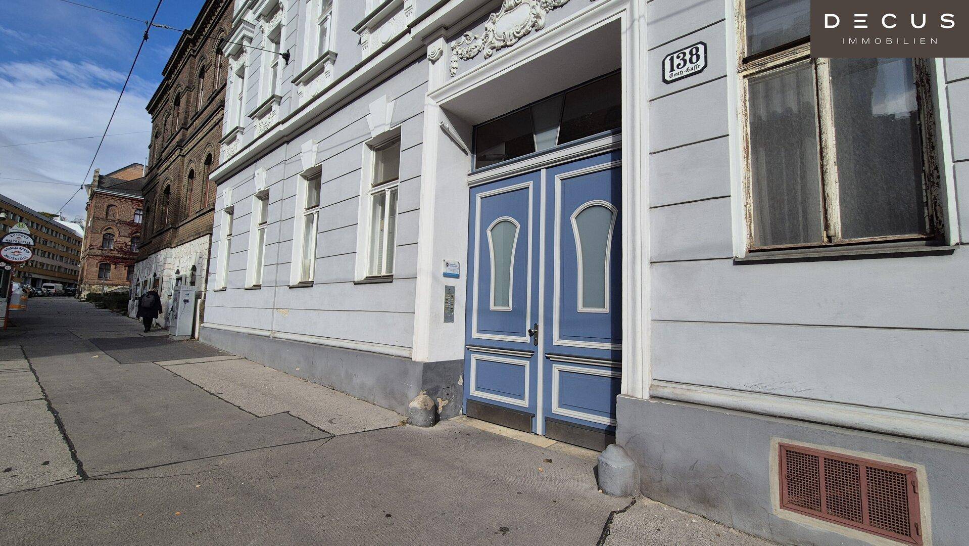 Eingangsbereich des historischen Gebäudes mit blauer Doppeltür und Hausnummer an der Straßenseite.