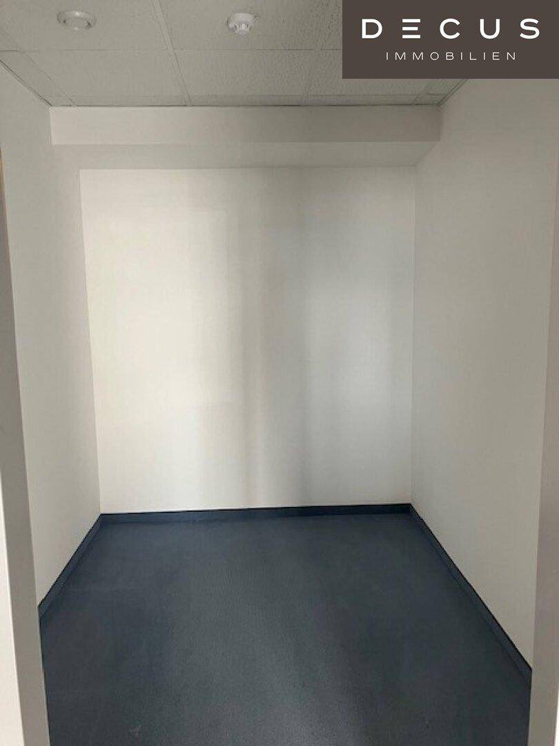 Kleiner, leerer Abstellraum mit Vinylboden und weißen Wänden, ideal für Lagerzwecke.