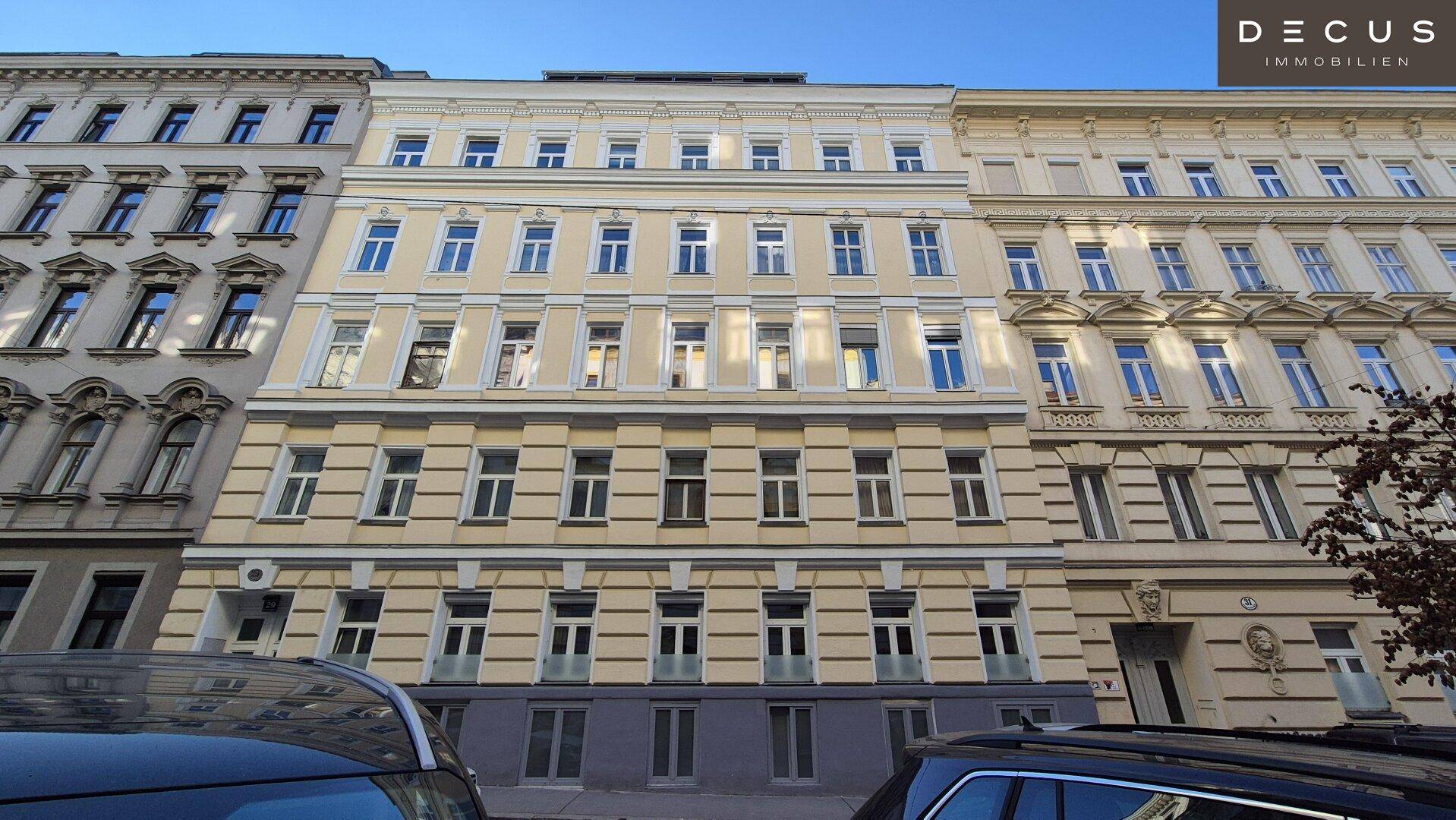 Fassade eines historischen Mehrfamilienhauses mit zahlreichen Fenstern und klassischer Architektur.