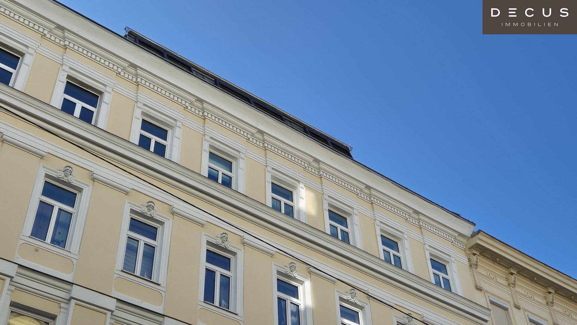 Detailansicht der oberen Etagen eines historischen Gebäudes mit vielen Fenstern.