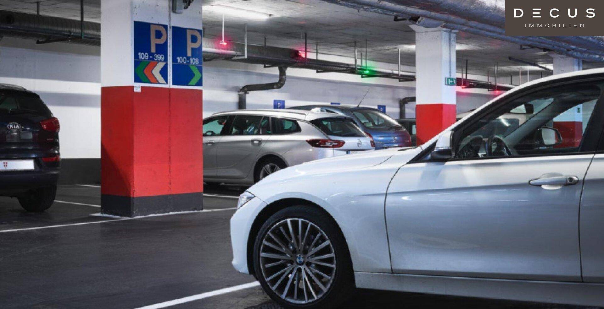 Helle Tiefgarage mit markierten Parkplätzen und geparkten Fahrzeugen.