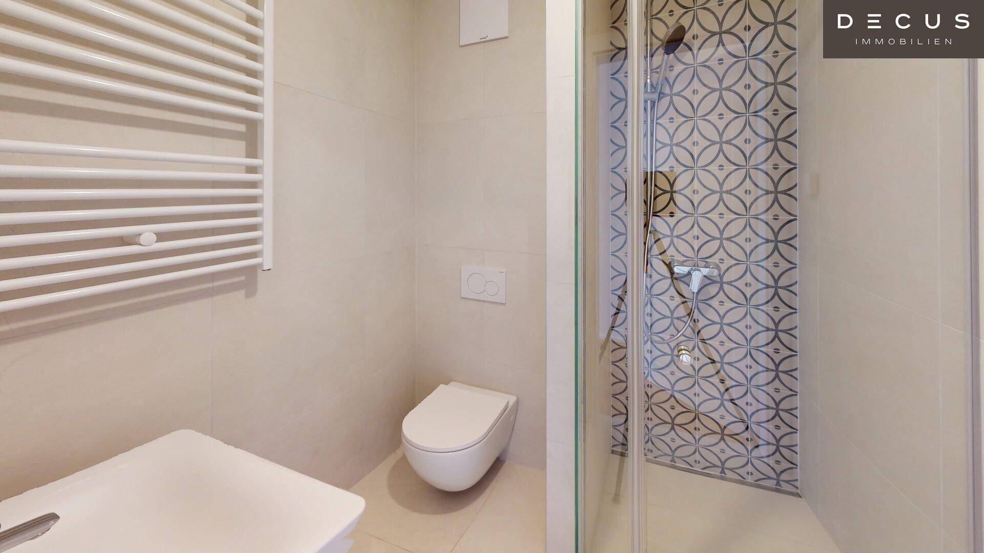 Modernes Badezimmer mit Duschkabine, wandhängendem WC und beheiztem Handtuchhalter.