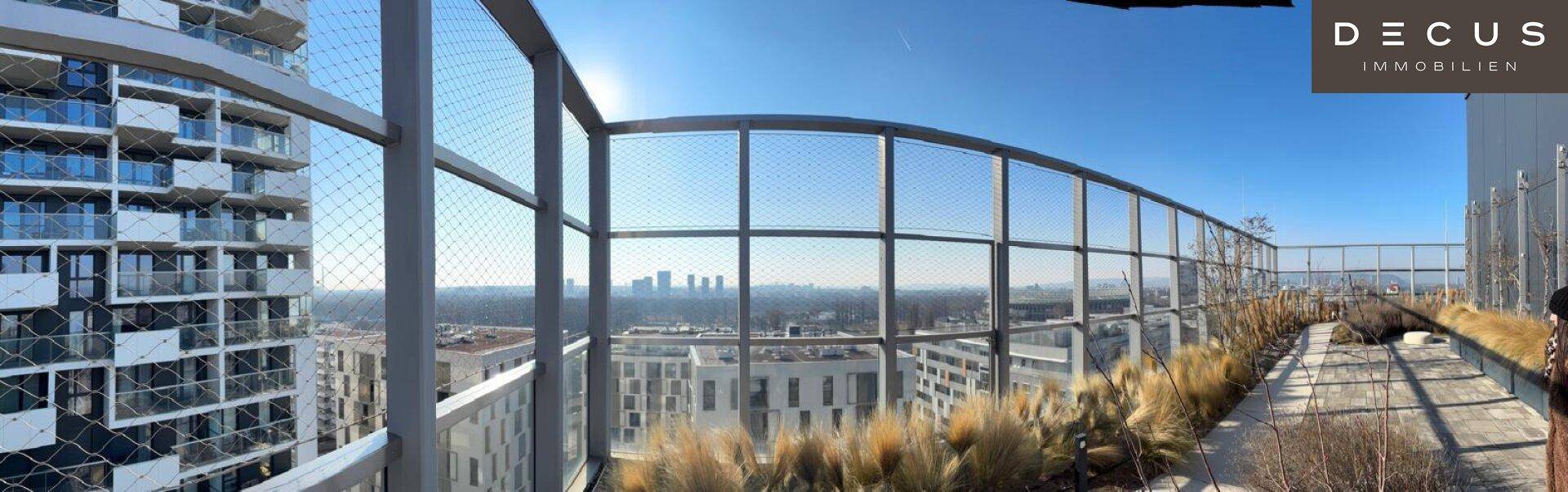 Weitläufige Dachterrasse mit Panoramablick über die Stadt und den Horizont an einem sonnigen Tag.