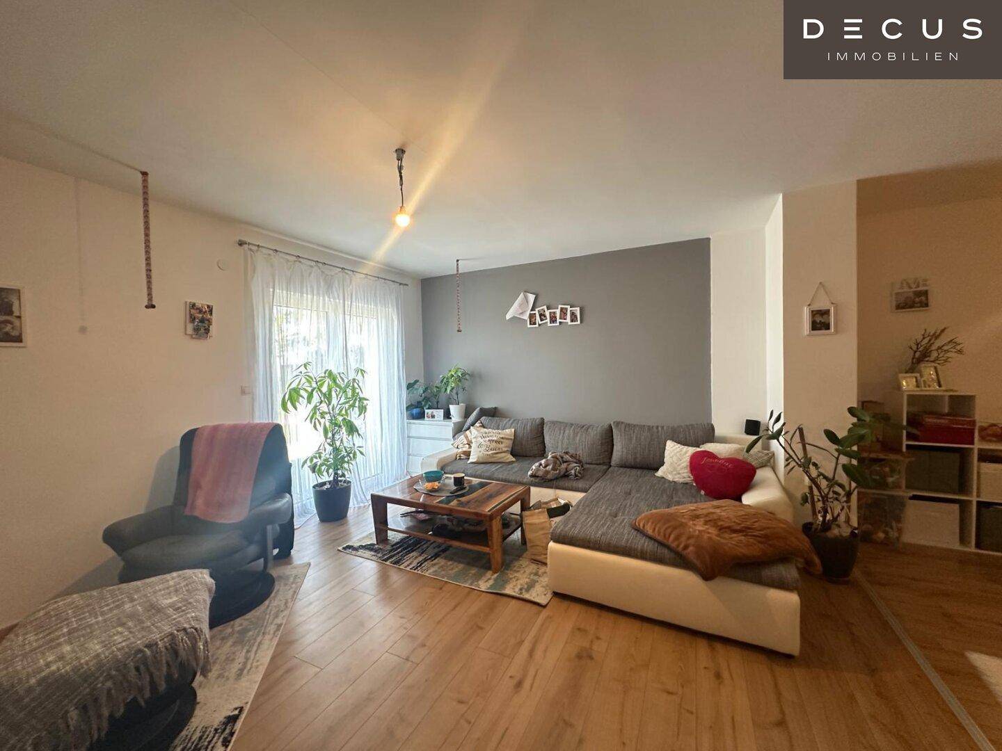 Gemütliches Wohnzimmer mit großem Sofa, Holzboden und Zugang zum Außenbereich.