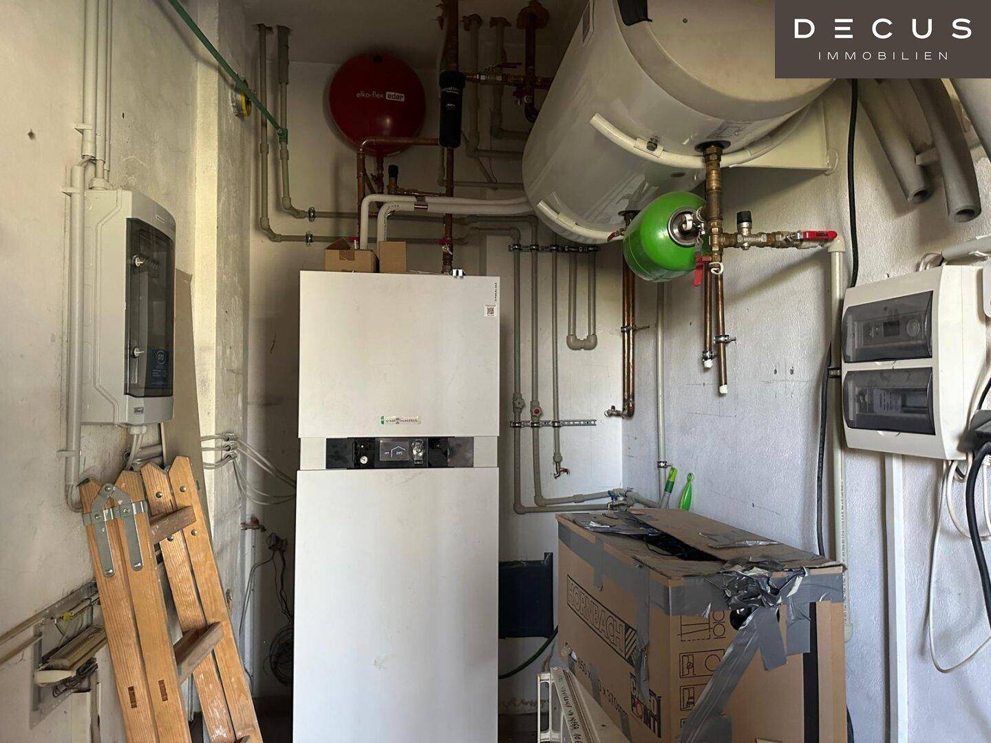 Heizungsraum mit Warmwasserspeicher und technischen Installationen.