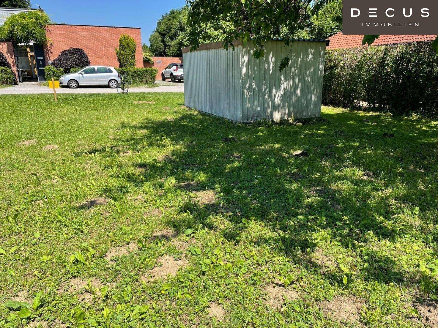 Gartenbereich mit einem kleinen Schuppen und umliegender Hecke, bietet Potenzial zur Gestaltung.