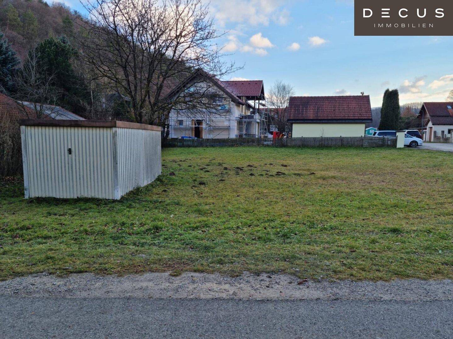 Grundstück mit Schuppen und Blick auf die umliegende Landschaft sowie ein Haus im Bau.