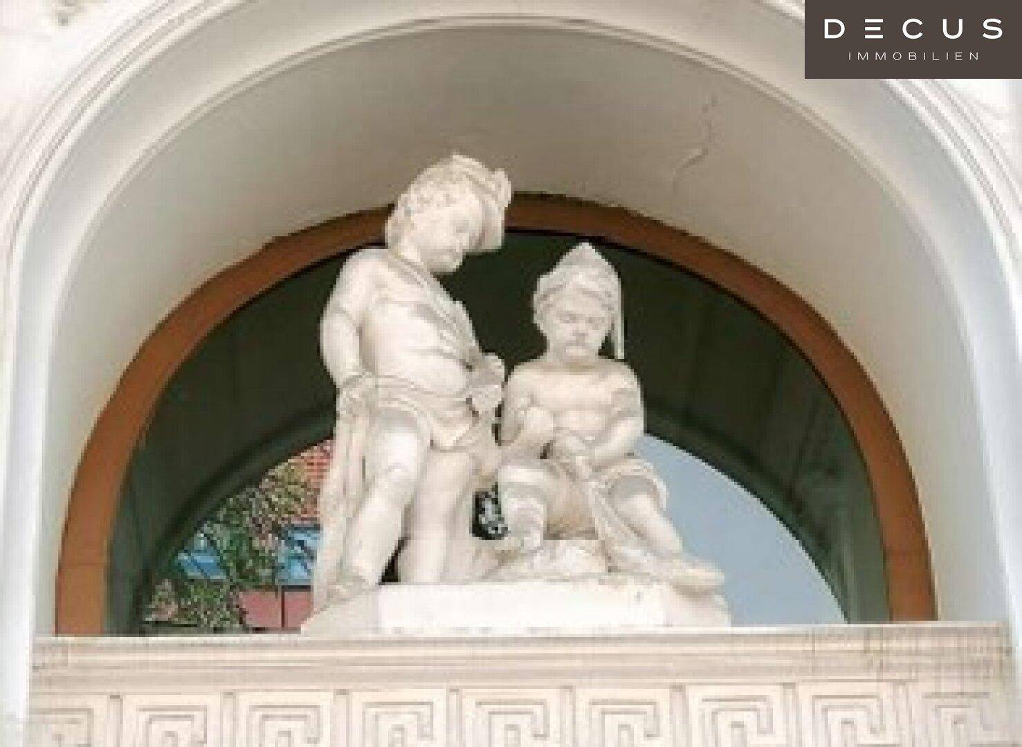Detailaufnahme einer weißen Steinskulptur unter einem Bogen, die klassische Architektur zeigt.
