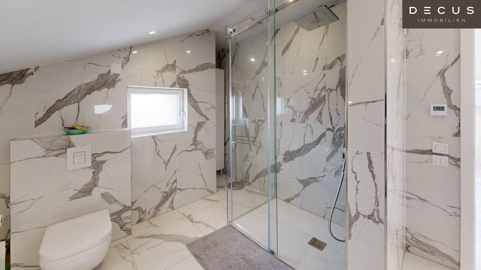 Modernes Badezimmer im Dachgeschoss mit begehbarer Dusche und Marmorfliesen.