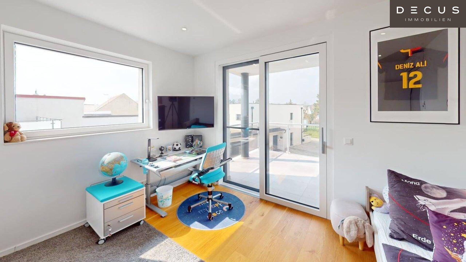 Helles Kinderzimmer mit Schreibtisch, Holzboden und Zugang zu einem Balkon oder Terrasse.