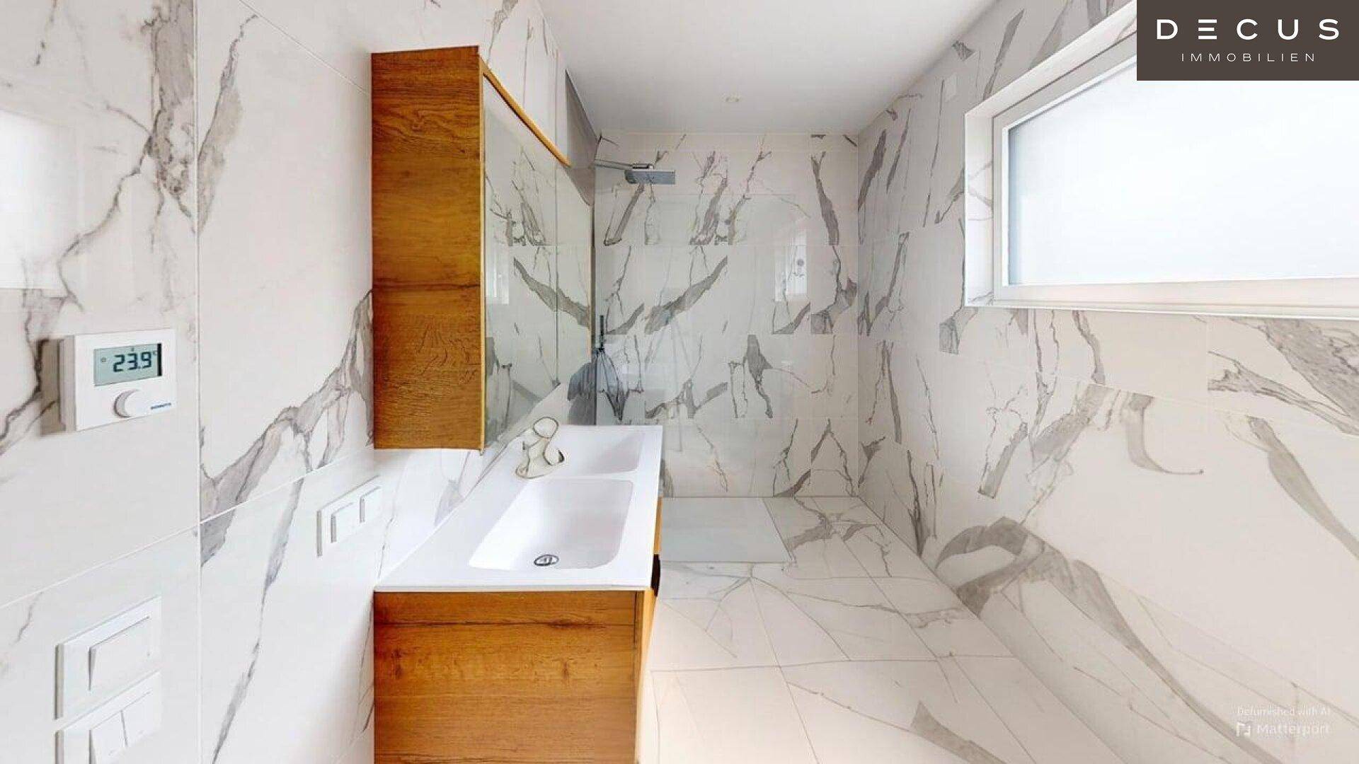 Stilvolles Badezimmer mit Doppelwaschbecken, Holzunterschrank und Marmorfliesen.