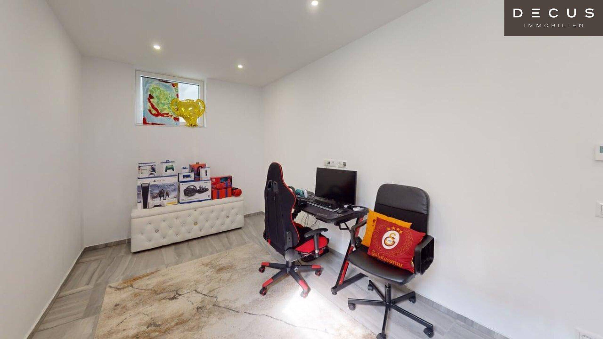 Heller Kellerraum, eingerichtet als Gaming-Zimmer mit Schreibtischen und Stauraum.