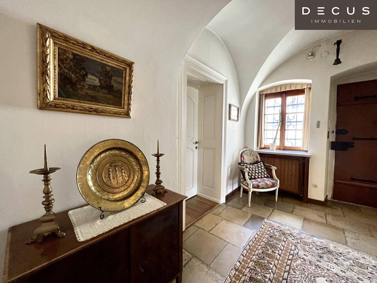 Historischer Flur mit Kreuzgewölbe, Steinfliesenboden und antiken Dekorationen, sehr elegant.