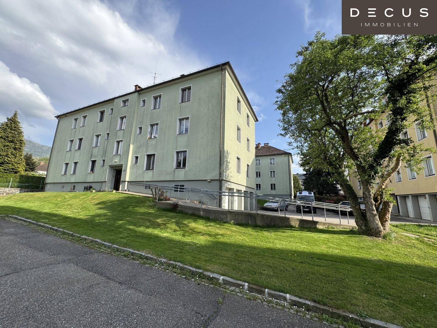 Mehrfamilienhaus mit Rampe für barrierefreien Zugang und Grünflächen.