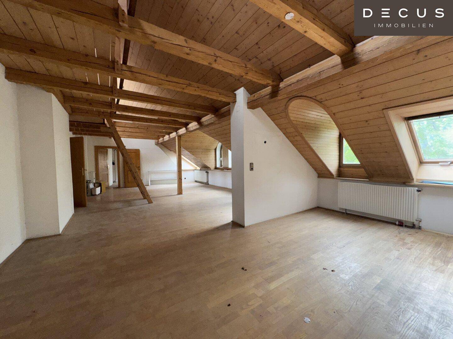Heller Dachbodenraum mit Holzbalken, Dachschrägen und Holzboden, ideal zum Ausbau.
