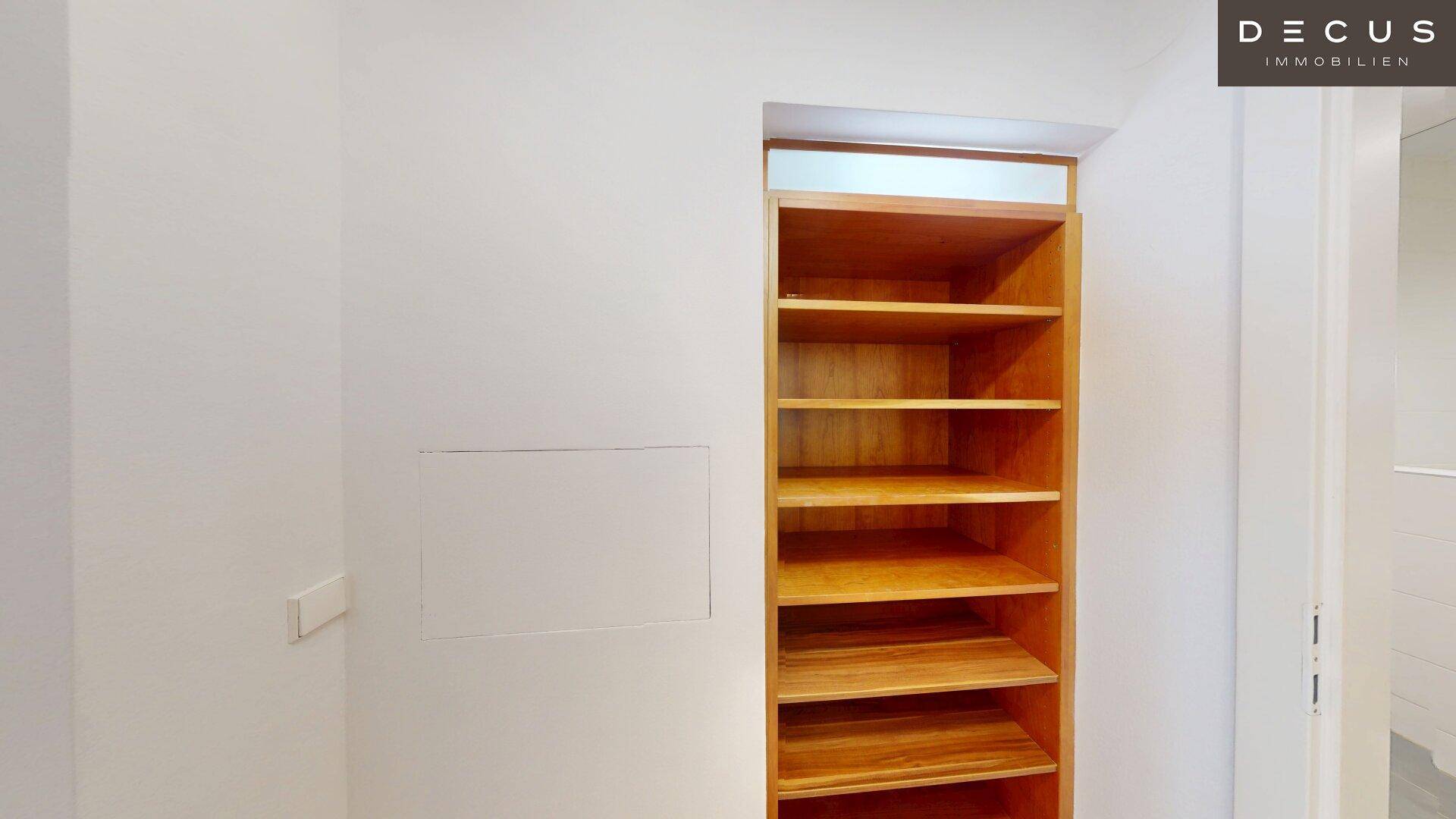 Praktisches, offenes Holzregal für zusätzlichen Stauraum in einem hellen Innenraum.