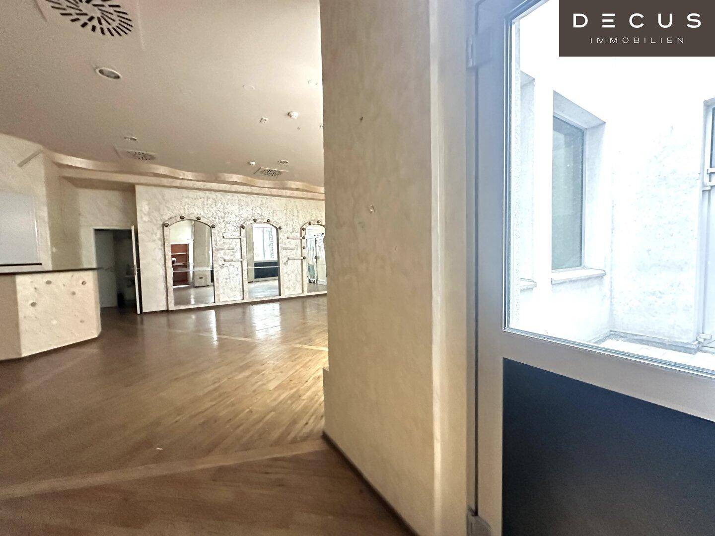 Blick durch den Gewerberaum auf den Eingangsbereich und die dekorativen Spiegelwände.