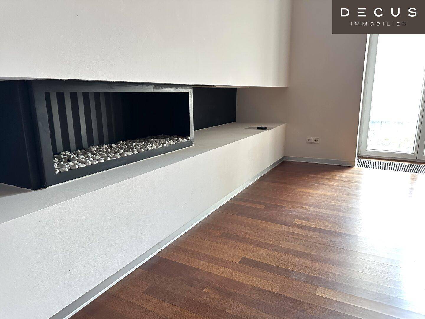 Detailansicht des modernen, in die Wand integrierten Kamins mit dekorativen Steinen.