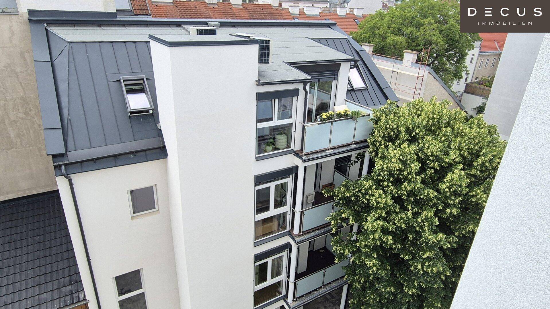 Moderne Dachgeschosswohnungen mit Balkonen und Schrägdach in urbaner Umgebung.