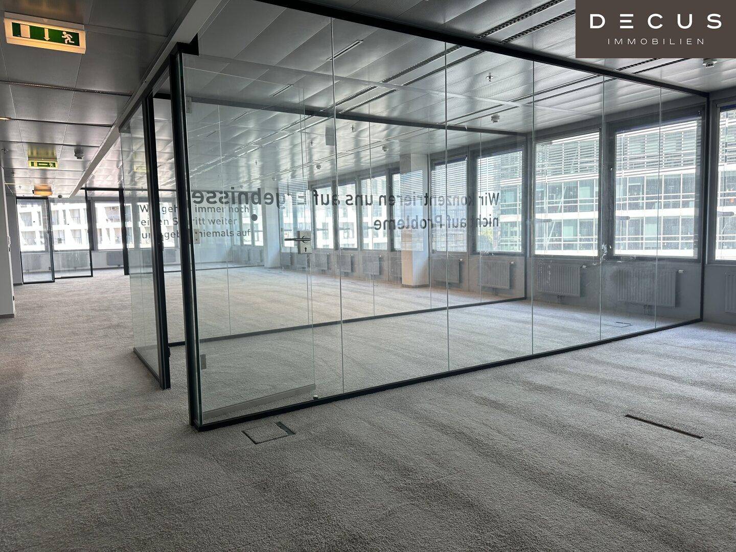 Geräumiges Büro mit Teppichboden und modernen Glaswänden, bereit zur individuellen Gestaltung.