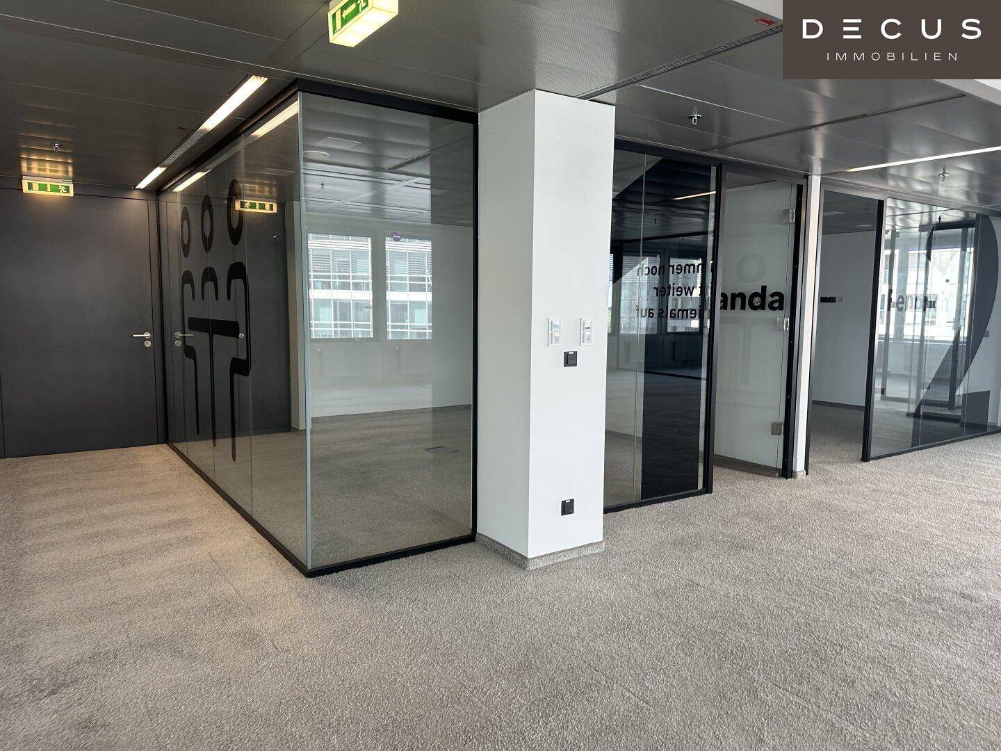 Moderner Bürobereich mit Glasabtrennungen und Zugangstüren, ideal für flexible Arbeitsplatzgestaltung.