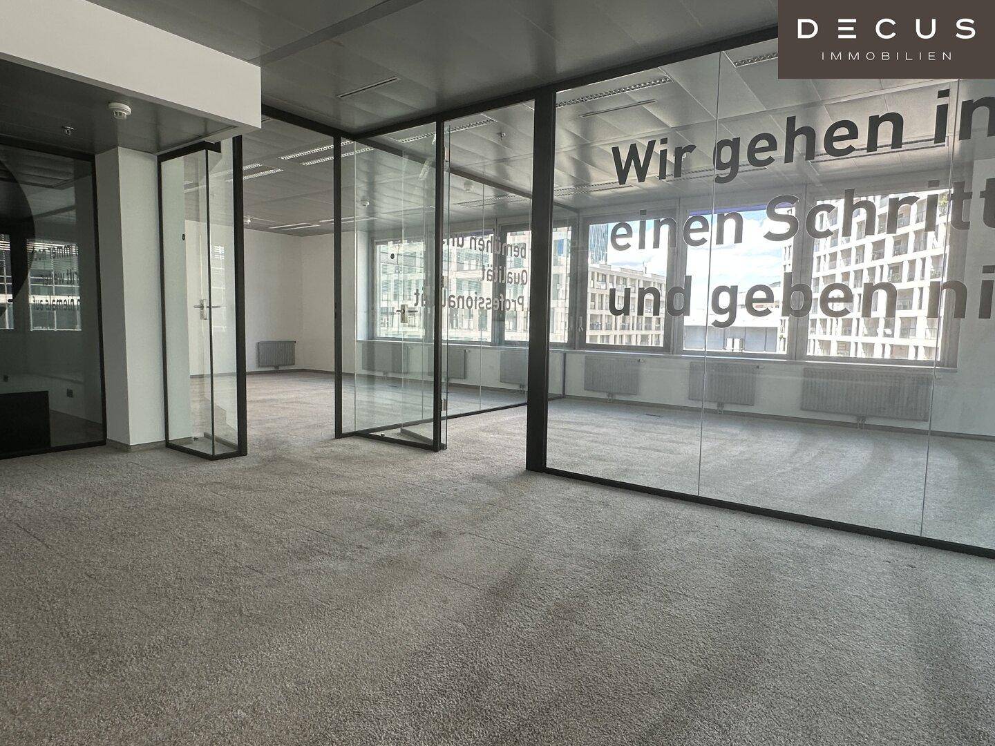Offener Bürobereich mit Glasabtrennungen und Teppichboden, bietet flexible Gestaltungsmöglichkeiten.