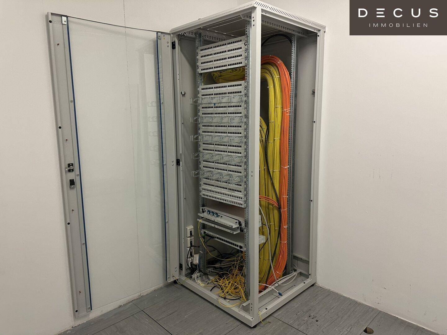 Serverschrank mit ordentlich verlegten Kabeln in einem Technikraum, bereit für den Anschluss.