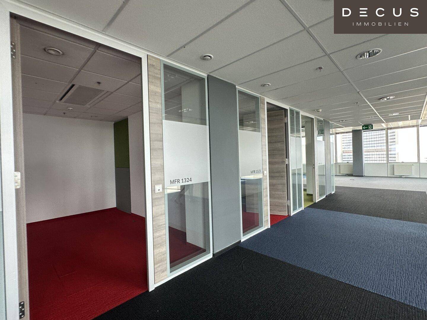 Reihe von modernen Bürozellen mit Glaswänden und Teppichboden, ideal für konzentriertes Arbeiten.