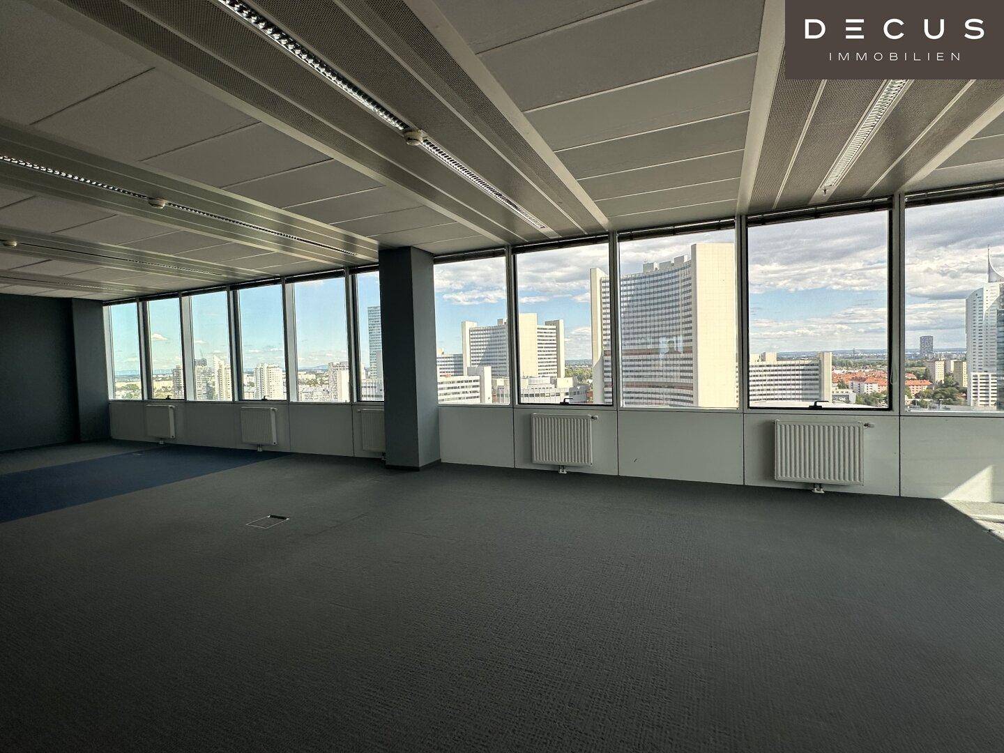 Großes Büro mit weitem Blick auf die moderne Skyline der Stadt durch die Fensterfront.