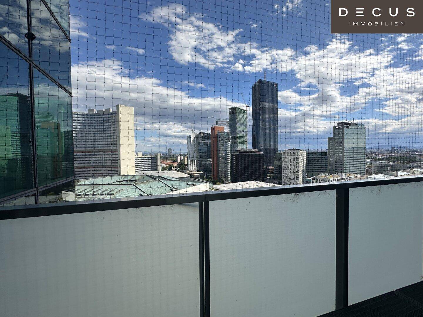 Panoramablick von einem Balkon auf die beeindruckende Skyline der Stadt unter blauem Himmel.