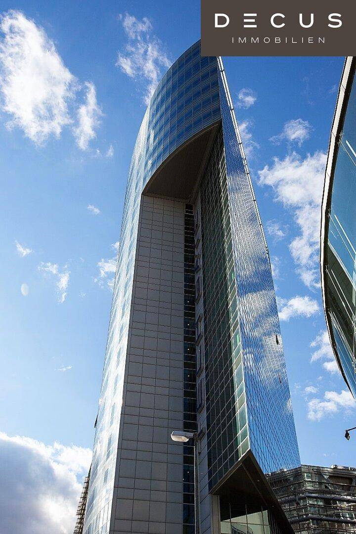Architektonisch anspruchsvolles Hochhaus mit geschwungener Glasfront, die den Himmel widerspiegelt.