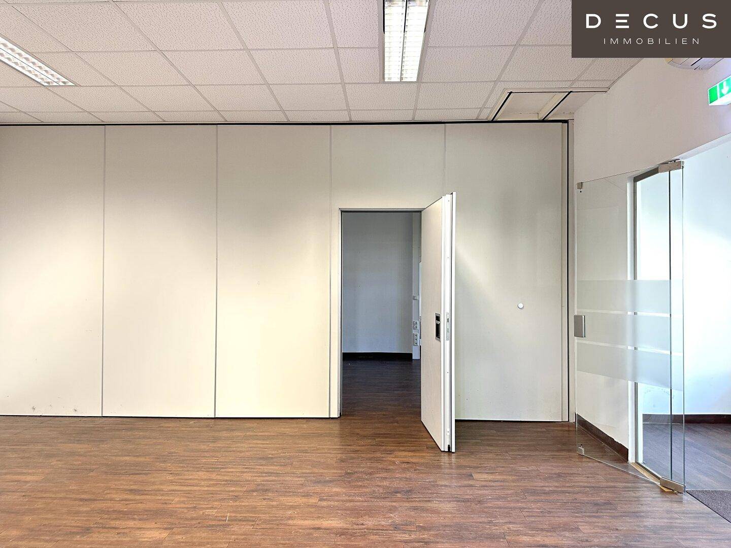 Flexibler Büroraum mit mobilen Trennwänden und Holzboden, bereit für individuelle Gestaltung.