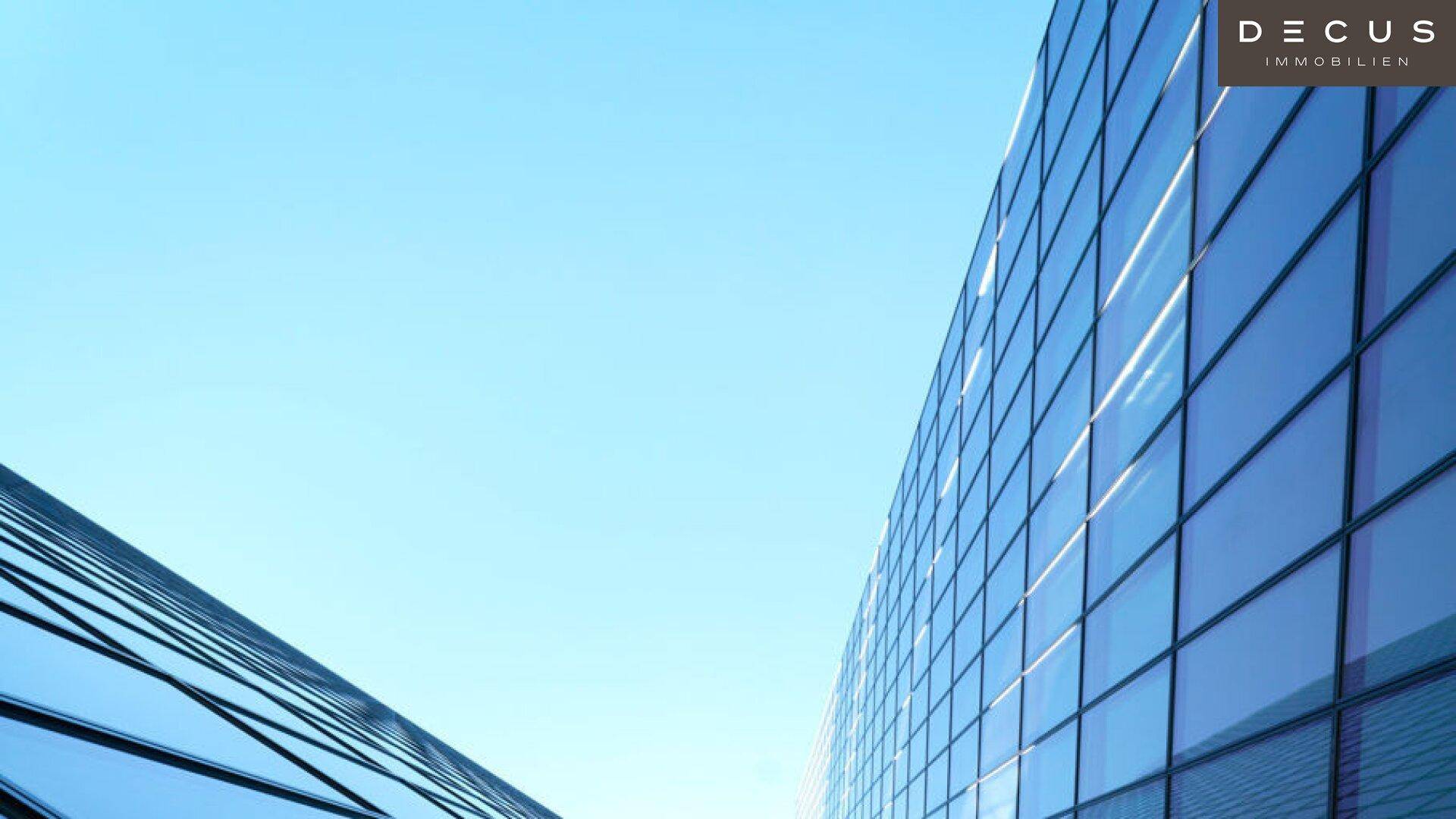 Moderne Glasfassaden von Hochhäusern spiegeln den klaren blauen Himmel wider.