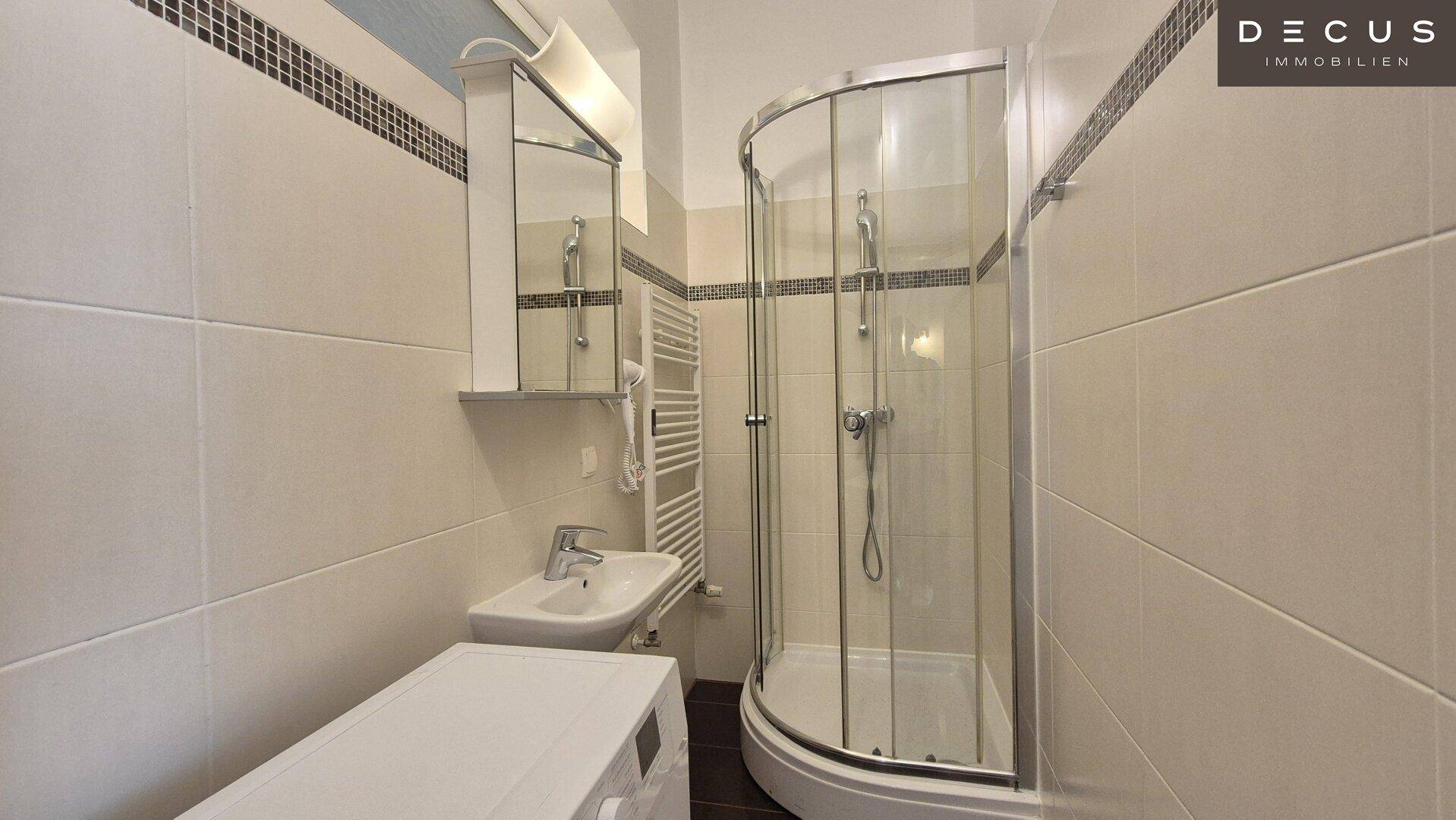 Modernes Badezimmer mit Duschkabine, Waschbecken, Waschmaschine und beheiztem Handtuchhalter.