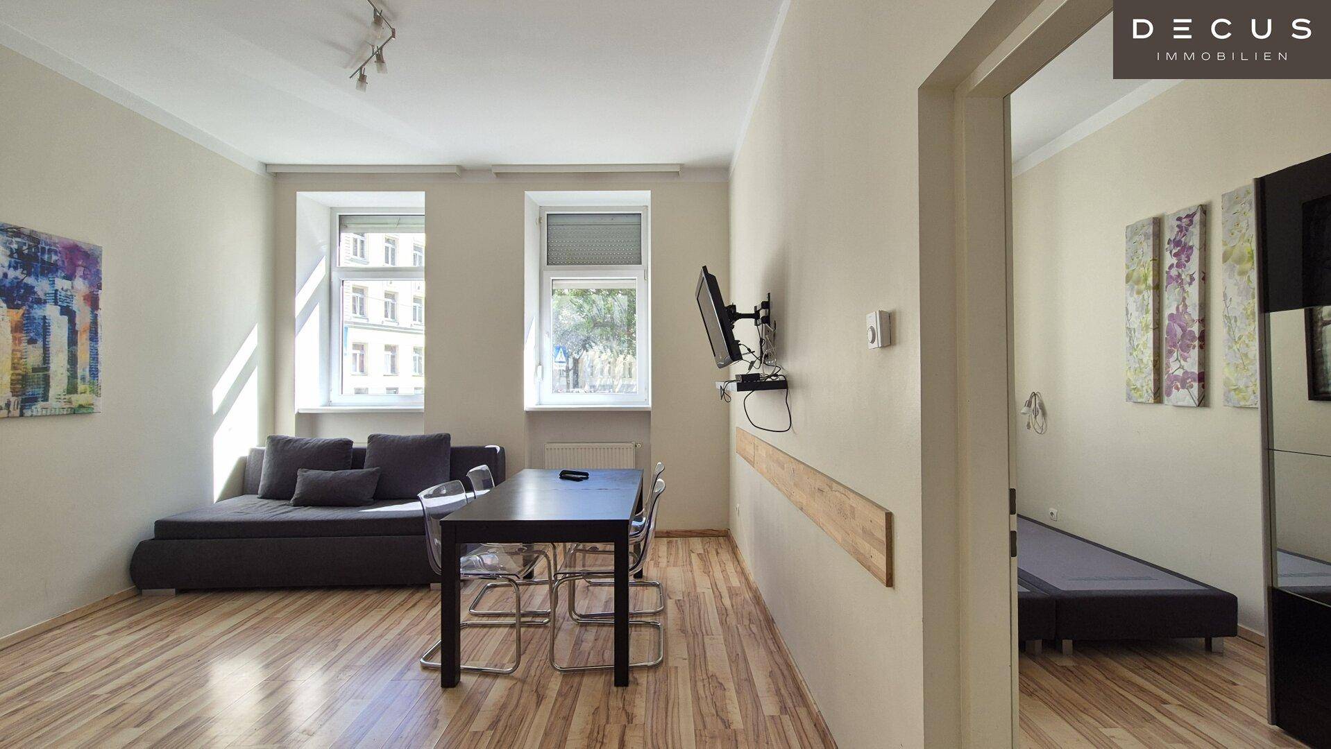 Offener Wohnbereich mit Esstisch und Zugang zu einem weiteren Zimmer.