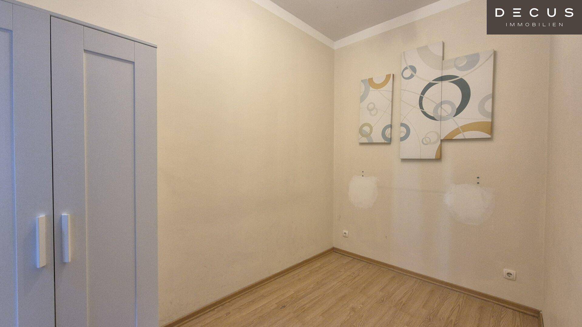 Zimmer mit Laminatboden und einem Kleiderschrank, bereit zur individuellen Gestaltung.