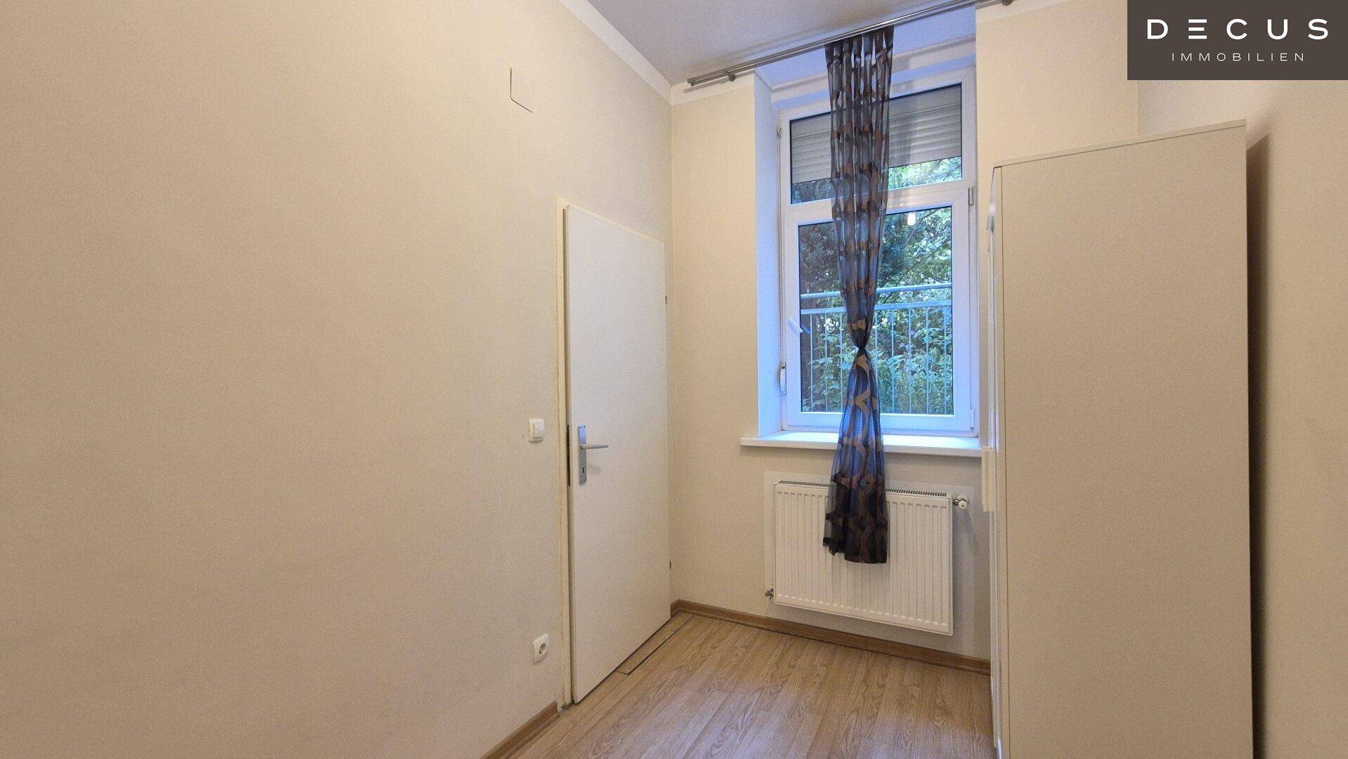 Einfaches Schlafzimmer mit Fenster, Heizkörper und hellem Laminatboden, ideal für Gäste oder Kinder.