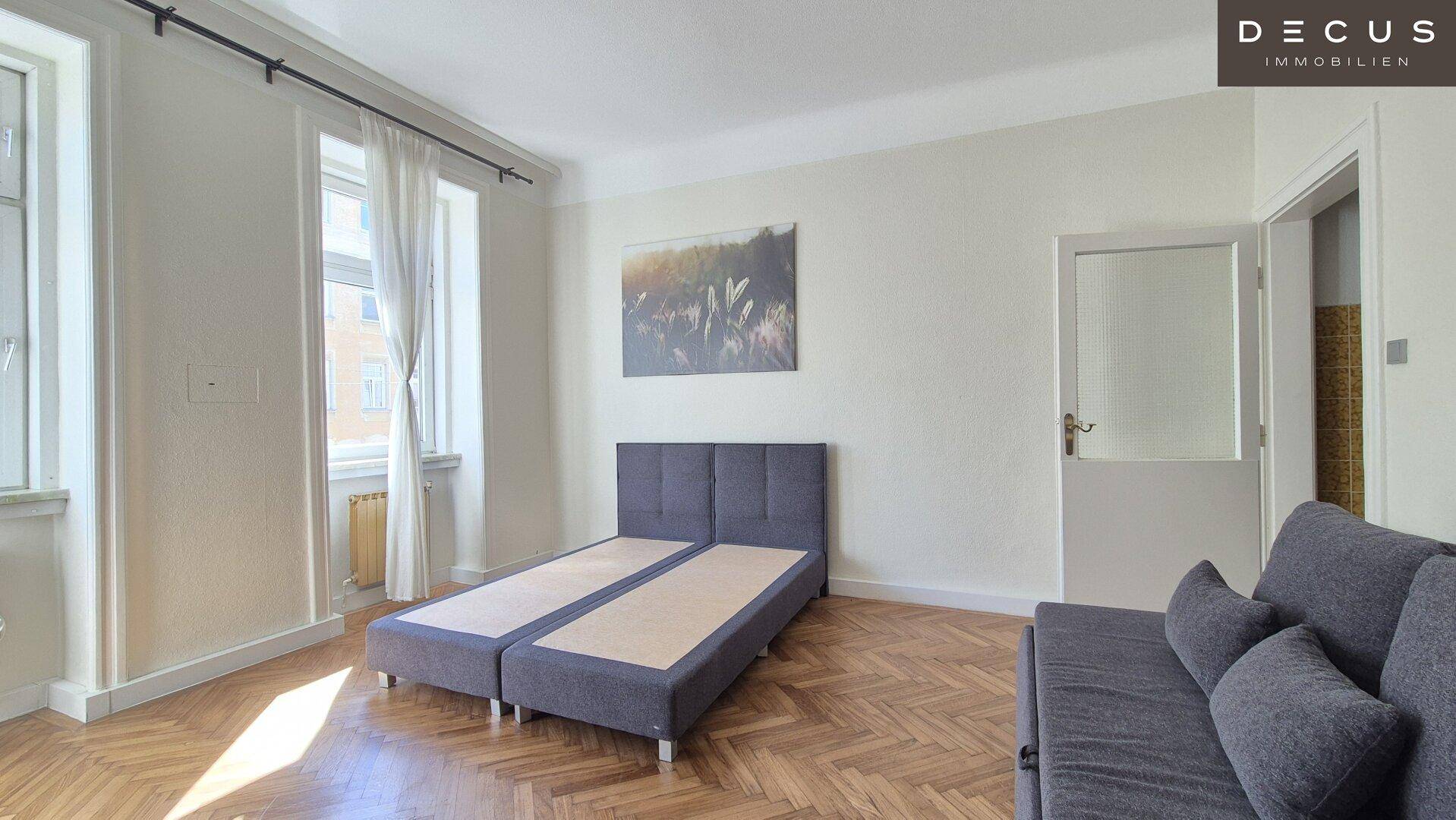 Schlafzimmer mit Fischgrätparkett und einem bequemen Bett, bereit für eine erholsame Nacht.