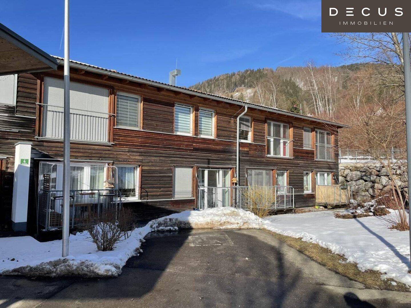 Holzfassade des Gebäudes mit mehreren Balkonen und Zugang zu den Wohneinheiten.