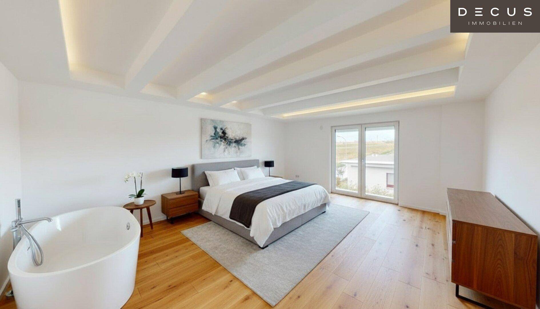 Helles Schlafzimmer mit Holzboden, freistehender Badewanne und Zugang zum Balkon.