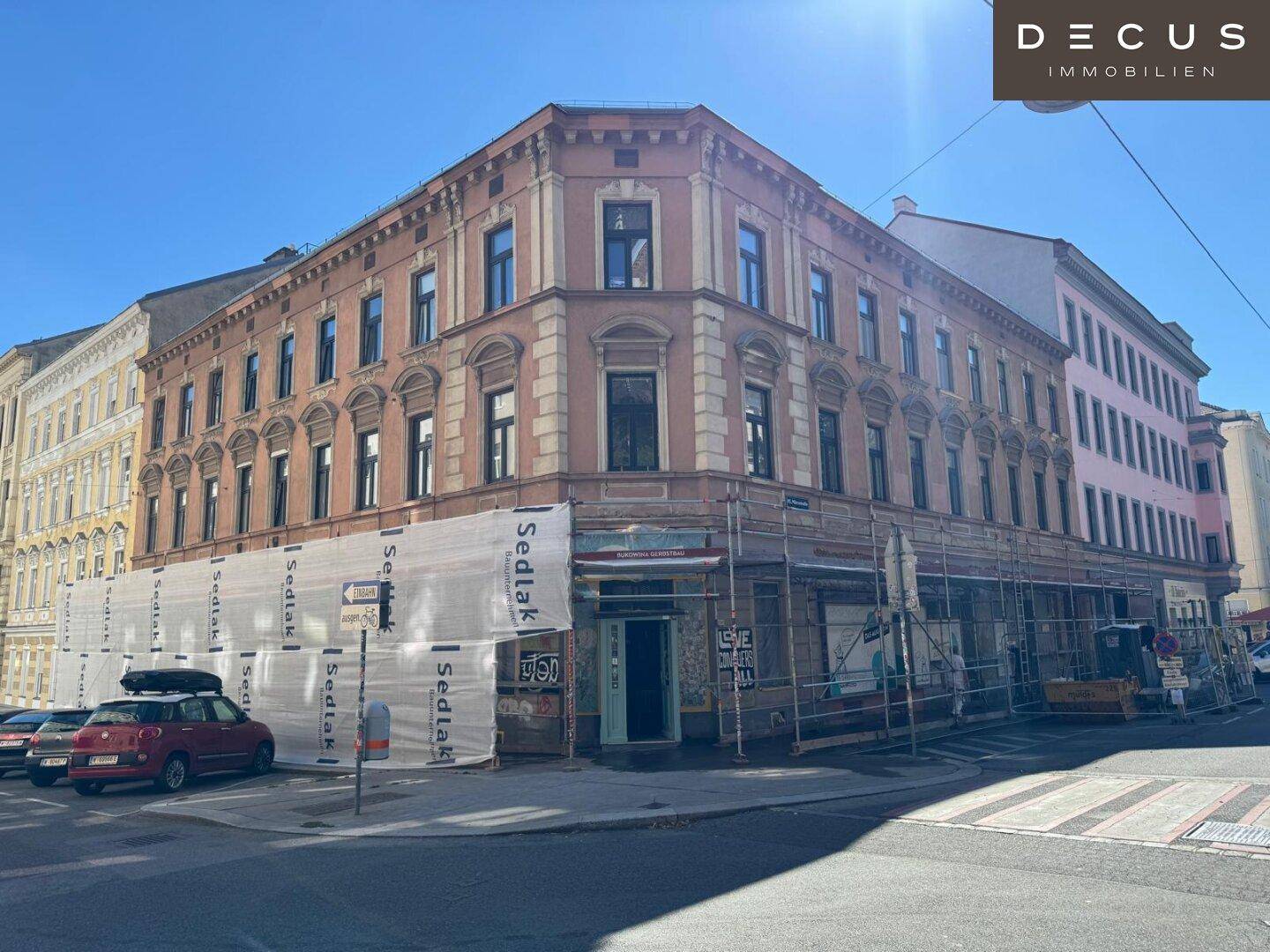 Historisches Eckgebäude mit Gerüst und Bauplanen, das auf eine bevorstehende Renovierung hindeutet.