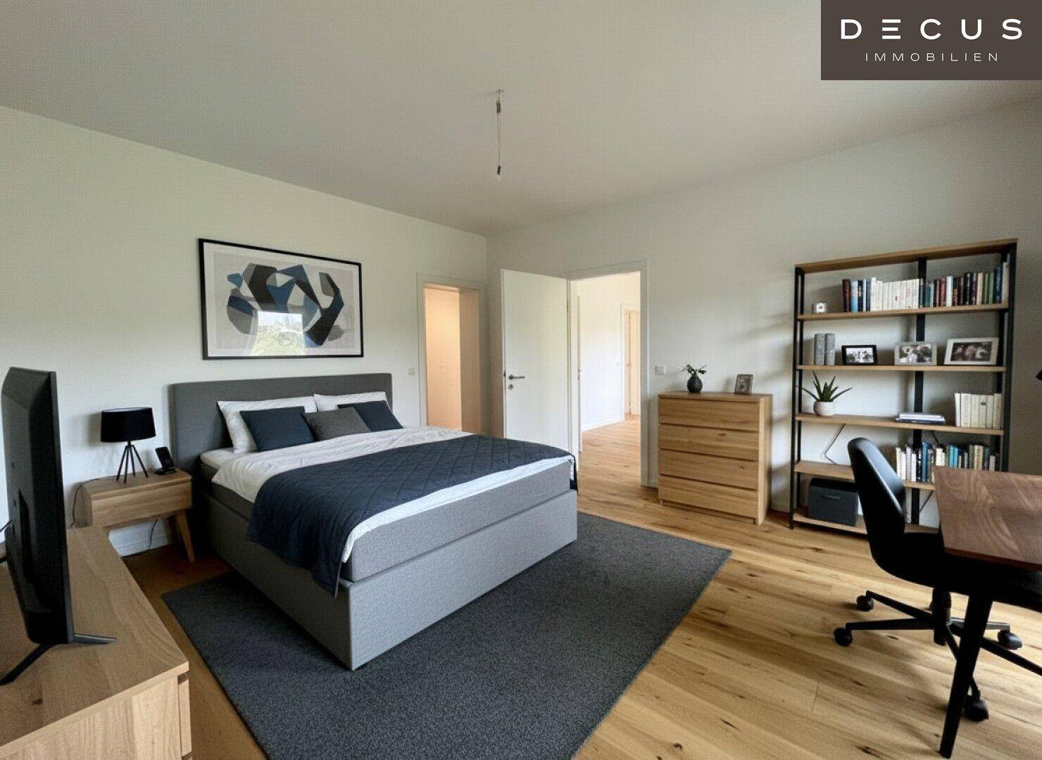 Geräumiges Schlafzimmer mit großem Bett, Holzboden und praktischem Bücherregal.