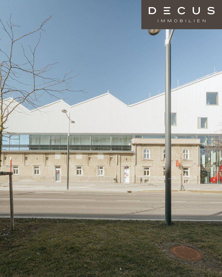 Moderne Architektur eines Gebäudes mit markantem Sägezahndach und großen Glasflächen an der Fassade.